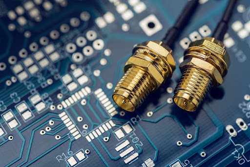 Two gold SMA coaxial connectors on an RF circuit board, the interface used by a coaxial switch in a signal path